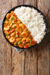 Louisiana shrimp Etouffee with vegetables cooked in roux sauce served with rice closeup in a plate. Vertical top view