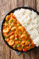 Shrimp Etouffee  Juicy dish smothered in rich and flavorful roux sauce served with rice closeup in a plate. Vertical top view