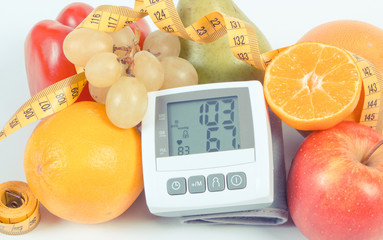 Vintage photo, Blood pressure monitor with result of measurement, fruits with vegetables and...
