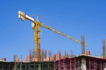 Yellow construction crane on the building