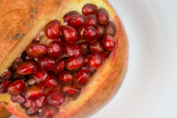 ripe open pomegranate on a white plate