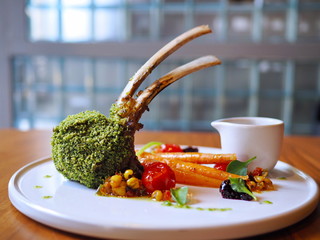 Perfectly grilled medium rare green herb crusted rack of Mottainai lamb from Australia gently...