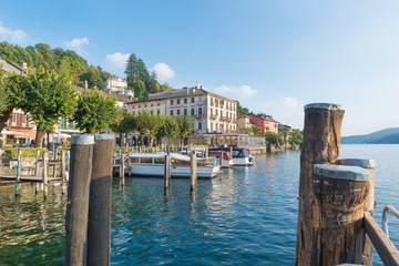 Lake Orta and the scenic village of Orta San Giulio, Italy. Jetties and boats on the lakefront in front of Piazza Motta (square Motta), located in the historic center of the town