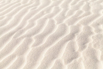 Fototapeta na wymiar White sand ripples, natural photo with selective focus. Abstract background