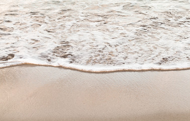 Wet coastal sand and sea water with foam, abstract background photo