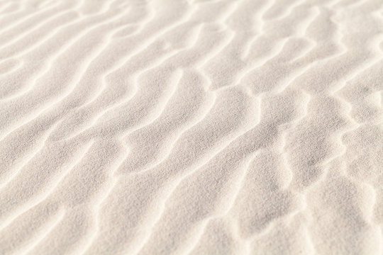 White sand ripples, natural photo with selective focus. Abstract background