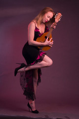 Blonde, in black dress with red flounces, with a mandolin in her hands on a Burgundy background of the Studio