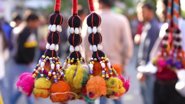 Dangling golden decorations with bells and puffs hanging in a store in chandni chowk delhi