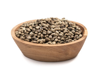 Brown oval wooden bowl with hemp seeds seen directly from the side and isolated on white background