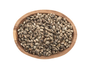 Brown oval wooden bowl with hemp seeds seen directly from above and isolated on white background