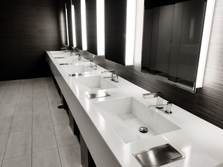 Public empty restroom with washstands, baby changer, and toillets in mirror. White sink row with mirrors and lights. Top horizontal view copyspace