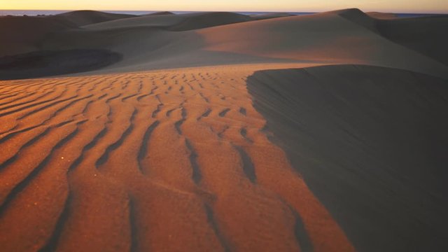 fantastic sunset in desert on Gran Canaria, Maspalomas, colorful slow motion walking along dunes with sand pattern, holiday travel concept