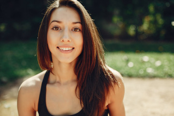 Beautiful girl in a park. Stylish girl in a sport clothes