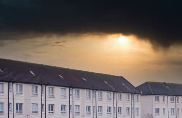 Poor council housing estate now abandoned and derelict under dark depressing storm sky UK