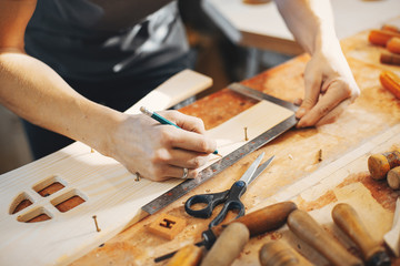 A man carves a tree. The carpenter works in a studio. An engineer provides a tree shape