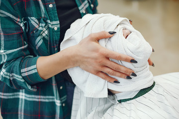 Man with a beard. Hairdresser with a client. Woman with a towel