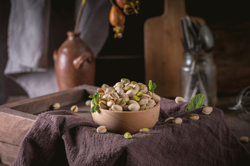 Obraz na płótnie Canvas Bowl with pistachios on a rustic background