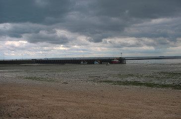 Fototapeta na wymiar Atlantic ocean shore with pier for shipping boats at Cancale, France