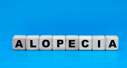concept word alopecia on cubes on a blue background