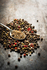 Fototapeta na wymiar Mixed peppercorns on the rustic background. Selective focus. Shallow depth of field.