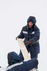 Two workers in overalls at a construction site