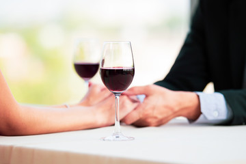 Husband and wife having a lunch and drinking a red wine together at the sky bar restaurant in valentine's day. Couple dinning together.