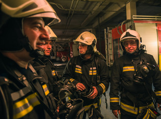 Group of firefighters with uniform inside the  fire station preparing for safe rescue