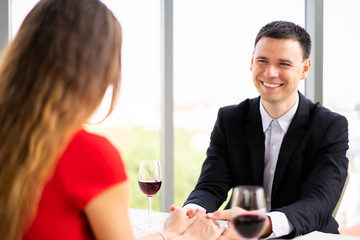 Caucasian people, husband and wife having a lunch together at the sky bar restaurant in valentine's day. Couple dinning together.