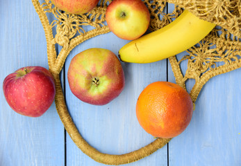 Various fresh fruits in a woven bag made of environmentally friendly material.