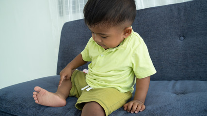 Fototapeta premium Cute little boy looking foot