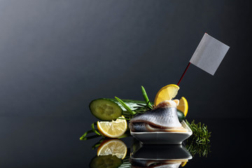 Herring fillet with lemon, green cucumber, onion and rosemary. Sandwich with herring fillet in oil.