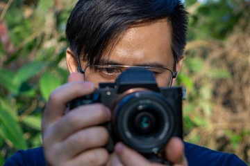 A close up asian man photographer in nature