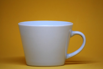 White cup isolated with yellow color pastel background - interior decorate backdrop