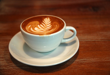 Hot Latte coffee in white cup on the table at coffee cafe backdrop - Drink and Relax chill out in the co working space cafe 