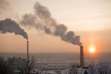Amazing pink winter sunrise. Beautiful xmas background. View from the window on the rooftops covered with snow. Winter morning.