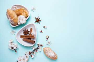 Croissants and spring flowering branches on a blue background. View from above