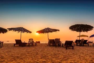 Parasols met ligstoelen bij zonsondergang op een tropisch zonnig strand in GOA, India © lucky-photo