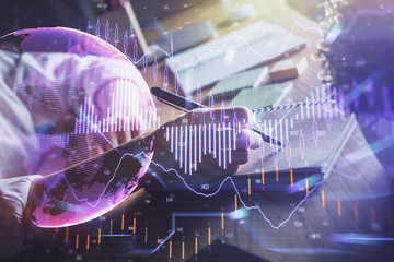 Financial forex charts displayed on woman's hand taking notes background. Concept of research. Double exposure