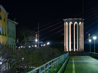 Illuminated water gauge tower on the dyke of Neuwied, Germany, close to the river rhine at night-time