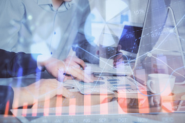 Multi exposure of chart with man typing on computer in office on background. Concept of hard work.