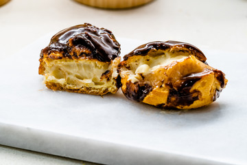 Half Cut Cream Filled French Dessert Chocolate Eclair. Close Up Macro View.
