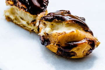 Half Cut Cream Filled French Dessert Chocolate Eclair. Close Up Macro View.
