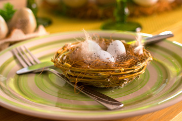 Decor in the form of Easter eggs on a plate on the table, home decoration for Easter holiday.
