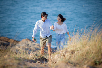 couples of asian younger man and woman relaxing at sea beach