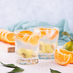 Summer refreshing non alcoholic cocktails with orange and kiwi fruits closeup still life. Summer...