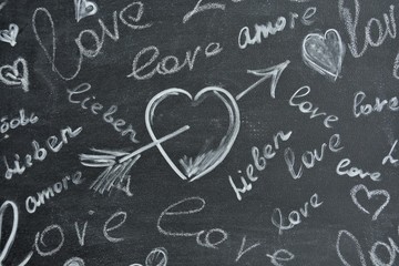 dark background with the word love written in white chalk and a painted heart