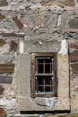 Fototapeta na wymiar Fragment of an old stone wall of an ancient building with window. Genoese fortress, Sudak, Crimea. Historic old building. Monument of architecture.
