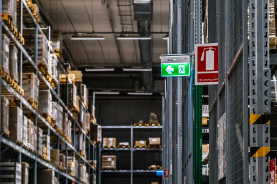Emergency exit route and Extinguisher sign on top of warehouse.