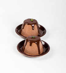 Italian dessert Panna cotta with chocolate sauce on a light background