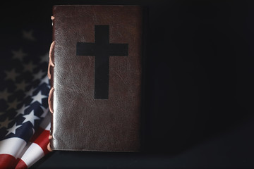 American flag and holy bible book on a mirror background. Symbol of the United States and religion....
